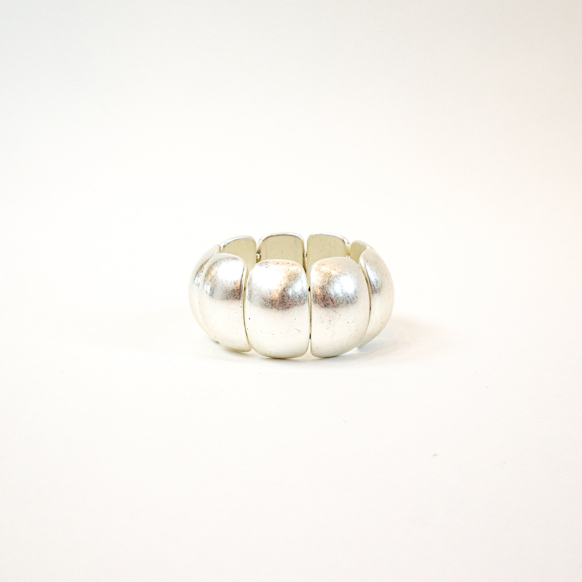 A bold and stylish chunky stretch bracelet featuring dome-shaped panels in gold or silver, adding a statement-making touch to any outfit.
