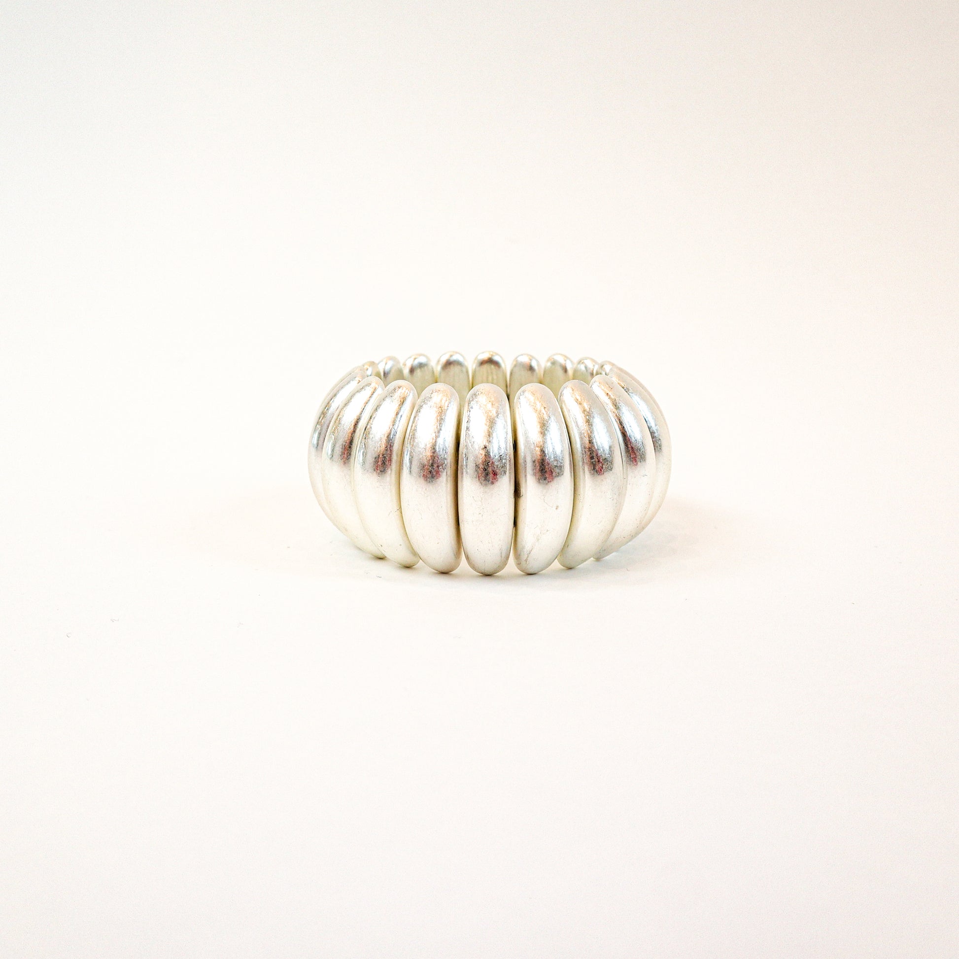 A bold and stylish chunky stretch bracelet featuring dome-shaped panels in gold or silver, adding a statement-making touch to any outfit.
