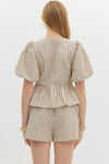 Striped Serenity Peplum Blouse with puff sleeves, bow-tie details, and a flattering peplum waist, styled with matching striped shorts for a chic, coordinated look.