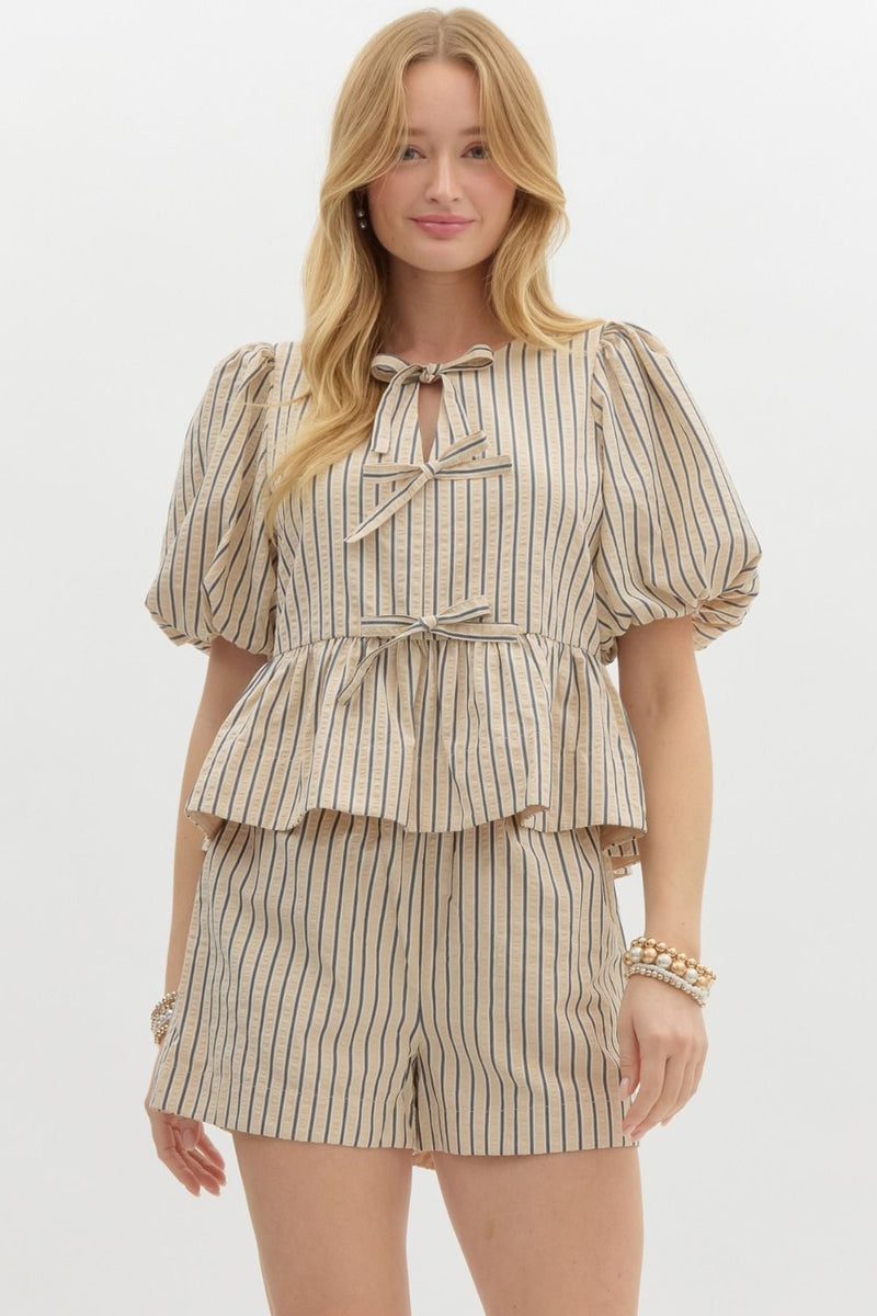 Striped Serenity Peplum Blouse with puff sleeves, bow-tie details, and a flattering peplum waist, styled with matching striped shorts for a chic, coordinated look.