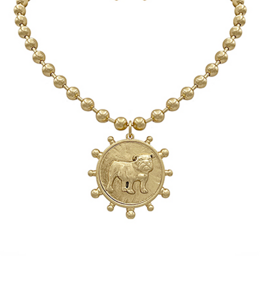  A gold-toned necklace with a beaded chain and a large circular medallion pendant featuring a detailed bulldog illustration, encircled by decorative nubs, all in gold.