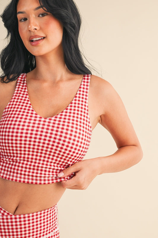 The Charlotte Gingham Performance Top features quick-drying, breathable fabric with four-way stretch and a removable bra pad for all-day comfort.
