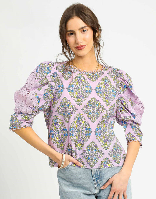 The Claudine Vintage Floral Blouse showcases a romantic floral print with statement puff sleeves, lace insets, and a scalloped crochet neckline for timeless charm.

