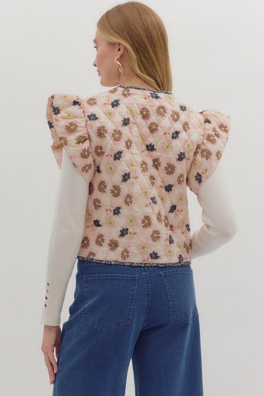 The Cleo Quilted Floral Vest features ruffled puff sleeves, contrast binding, and a toggle front closure for a statement layering piece with charm.

