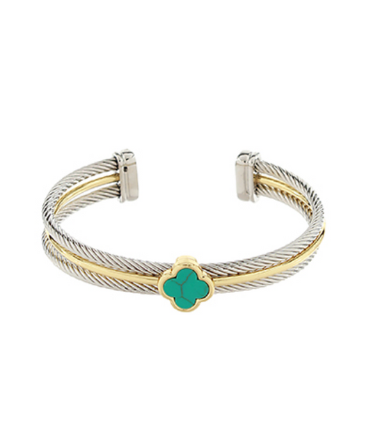 A two-tone cuff bracelet featuring a silver-toned cable twist design accented with a gold-toned band, centered with a turquoise-colored four-leaf clover motif.