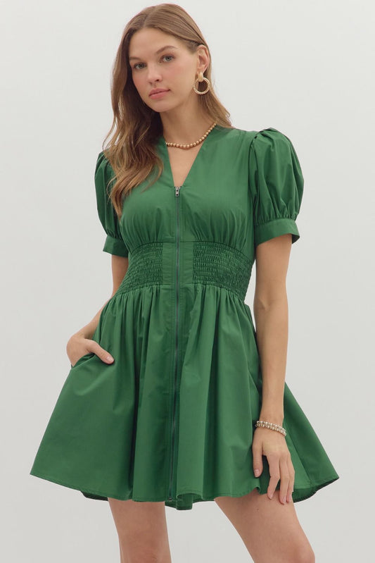 The Corrine Smocked Zip Mini Dress combines everyday ease with flattering structure, thanks to puff sleeves, a smocked waist, and front-zip detail.

