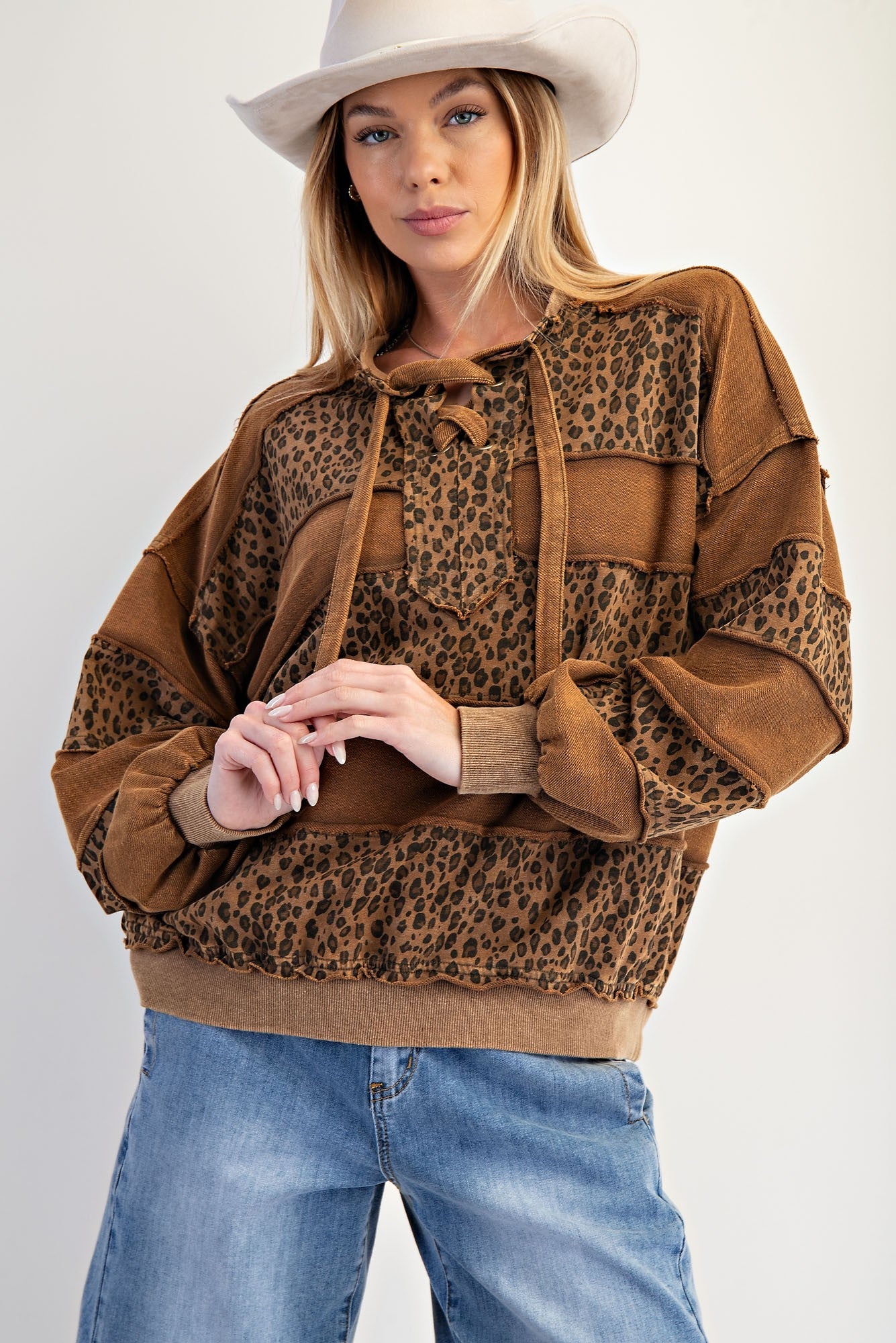 The Darla Pullover blends cozy terry comfort with bold animal print, stripe paneling, and lace-up neckline ties.