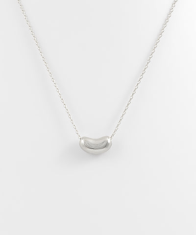 The Elsa Bean Charm Necklace features a playful bean-shaped charm with a delicate chain for everyday style.