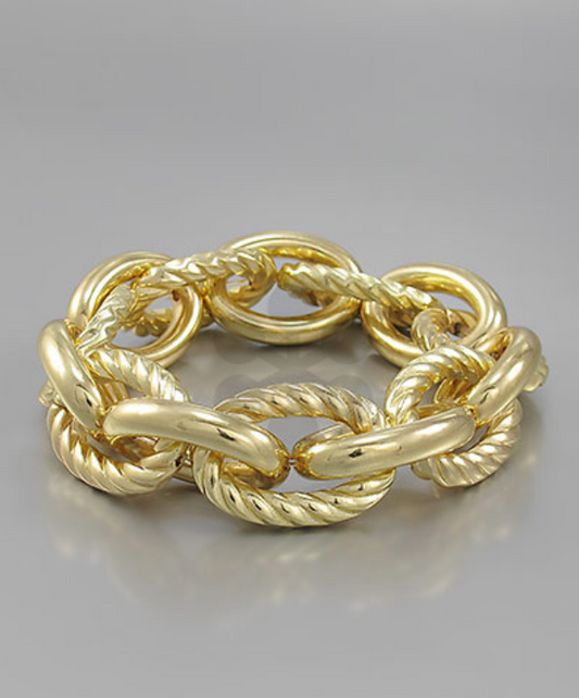  A luxurious, chunky gold-toned bracelet featuring alternating smooth, polished oval links and textured, rope-twist oval links, creating a sophisticated interlocked design.