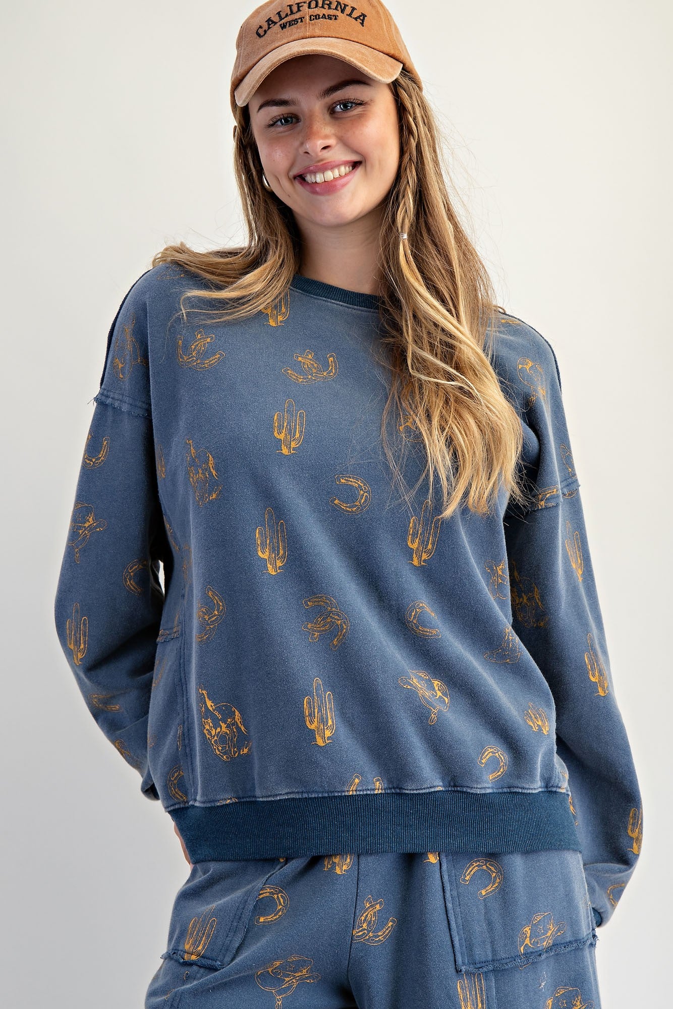 The Hollis Pullover features a mineral-washed western print, exposed seam details, and a relaxed crew neck fit—your new off-duty essential.