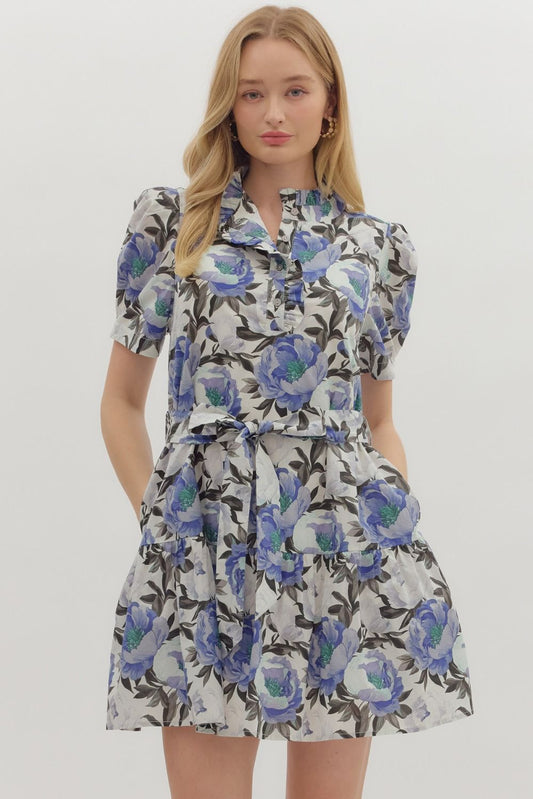 The Irena Floral Puff Sleeve Dress features a romantic ruffle neckline, removable belt, and side pockets for the perfect balance of charm and function.