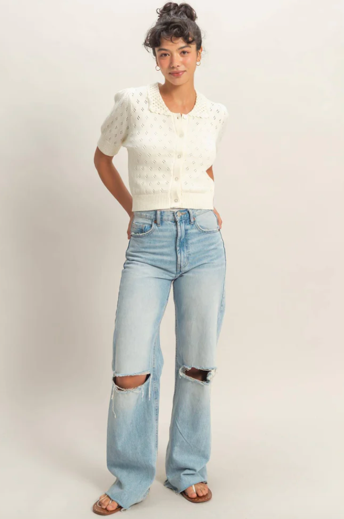 ivory cropped pointelle knit cardigan with short puff sleeves and button-front closure styled with high-waisted light wash jeans