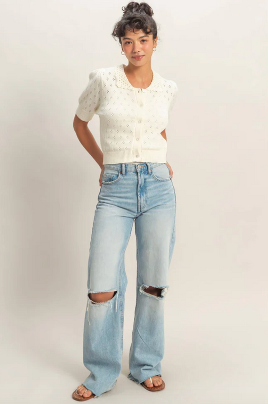 ivory cropped pointelle knit cardigan with short puff sleeves and button-front closure styled with high-waisted light wash jeans