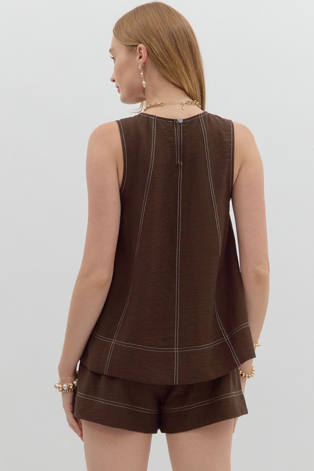 The Lorna Top keeps things effortlessly cool with contrast exposed stitching, a sleek sleeveless cut, and a keyhole back closure—all in a lightweight woven finish.

