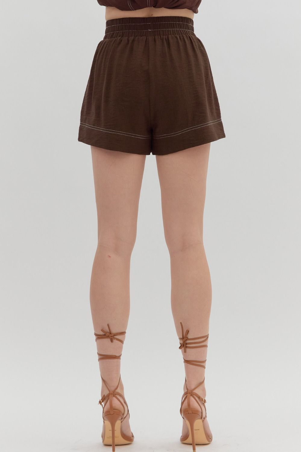 The Nadene Shorts offer utility with a stylish twist—featuring contrast stitching, roomy front cargo pockets, and a comfy elasticated high waist in a breezy woven blend.

