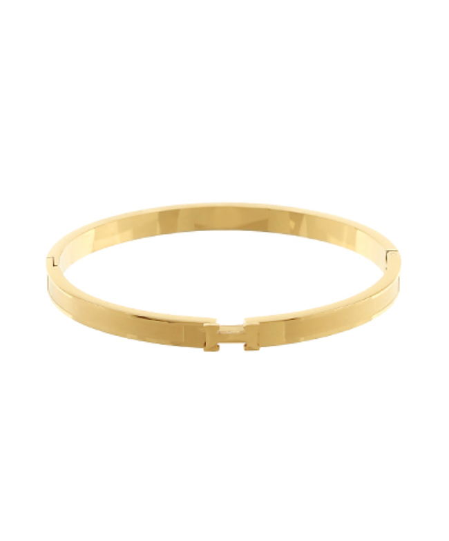 A sleek, polished gold-toned bangle bracelet featuring a central H-shaped clasp.