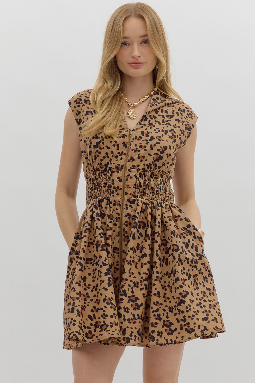 The Winona Dress blends bold leopard print with breezy comfort, featuring a zip-front neckline, smocked waist, and soft cotton lining for a fierce yet flattering look.

