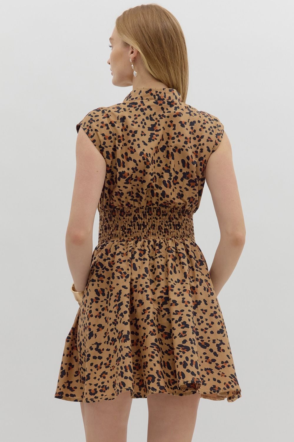 The Winona Dress blends bold leopard print with breezy comfort, featuring a zip-front neckline, smocked waist, and soft cotton lining for a fierce yet flattering look.

