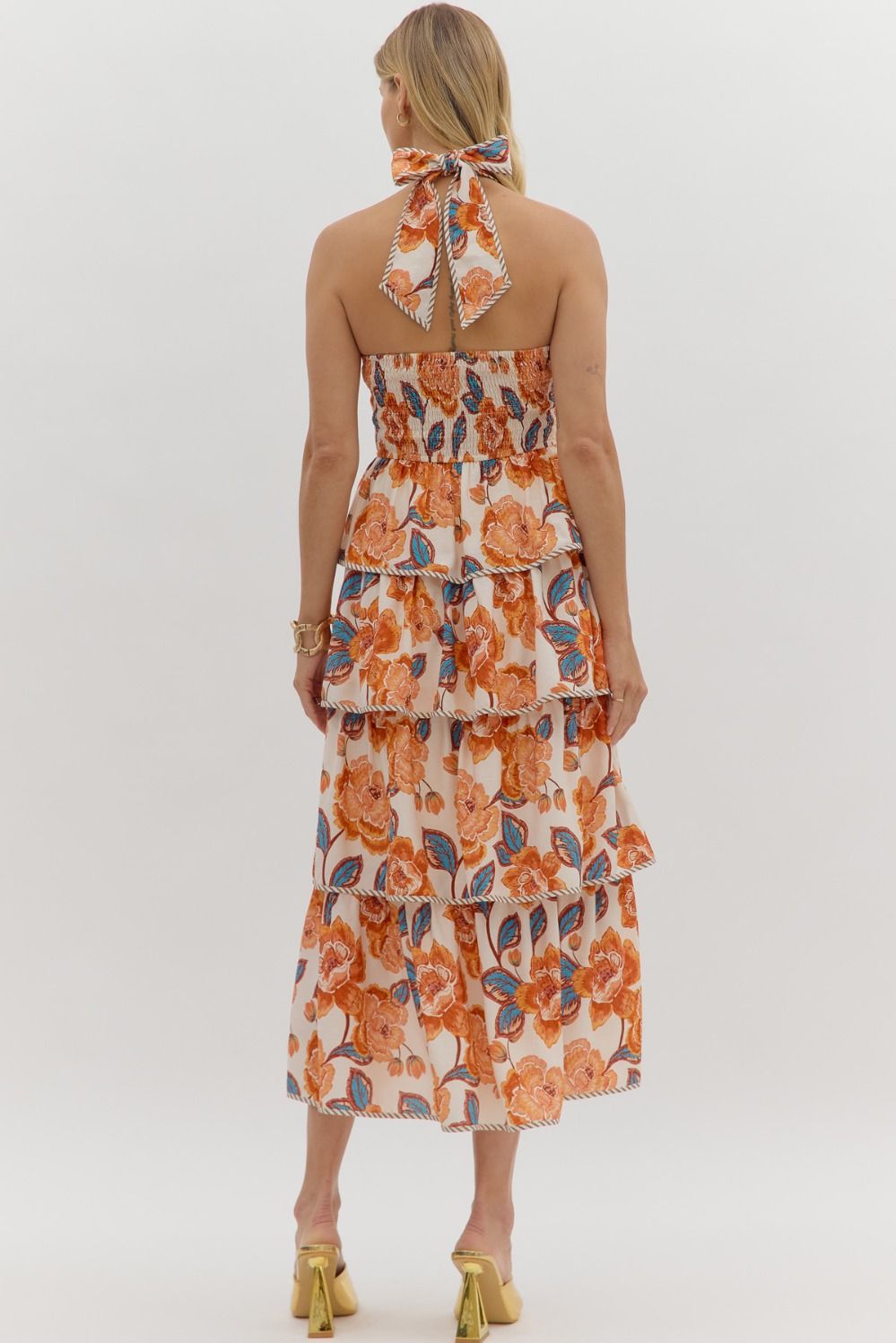 Tiered floral midi dress with a bow tie halter neckline, contrast binding, and smocked back.

