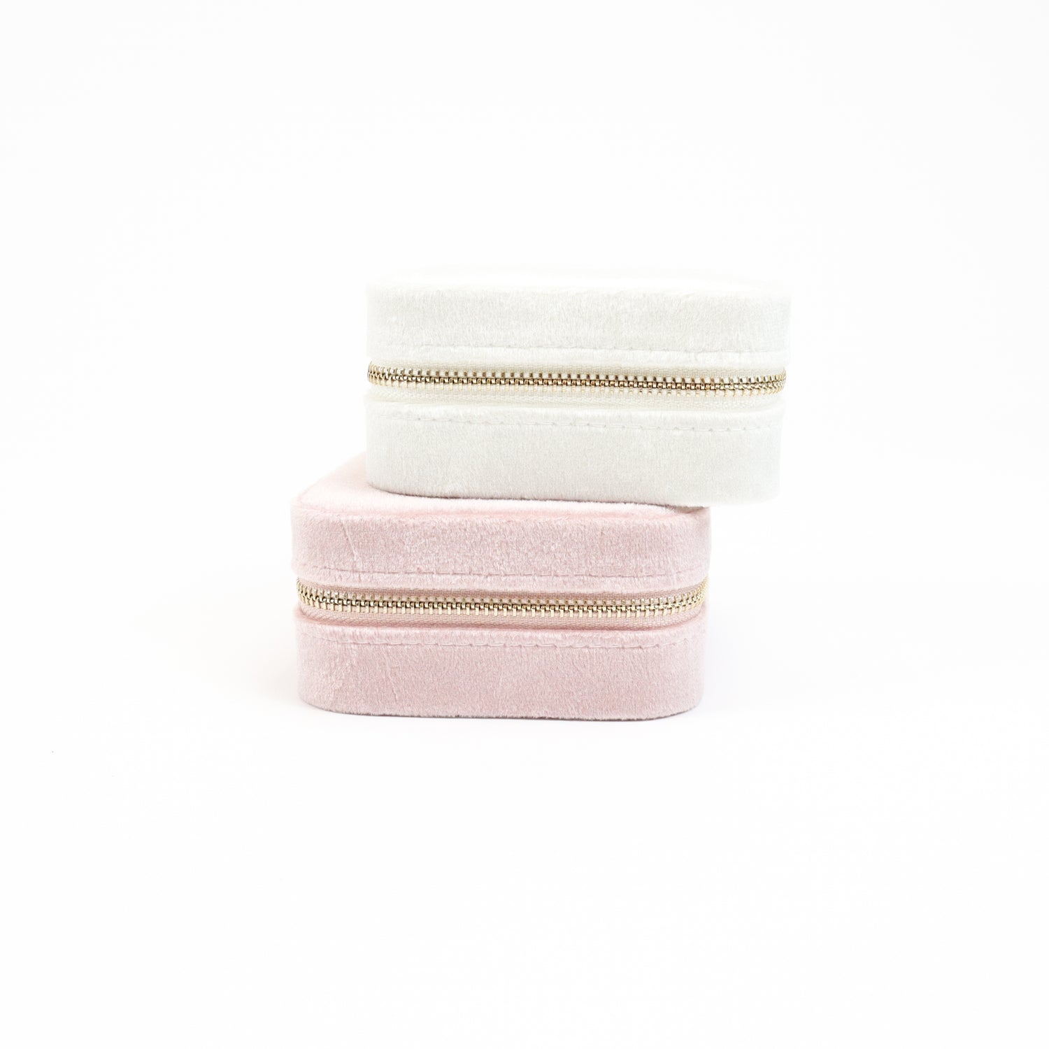 uxurious velvet travel jewelry cases in soft pink and ivory, featuring gold-tone zipper closures.