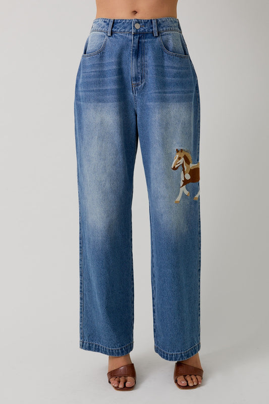 Wide-leg denim pants with embroidered horse motifs and a relaxed, vintage-inspired fit.
