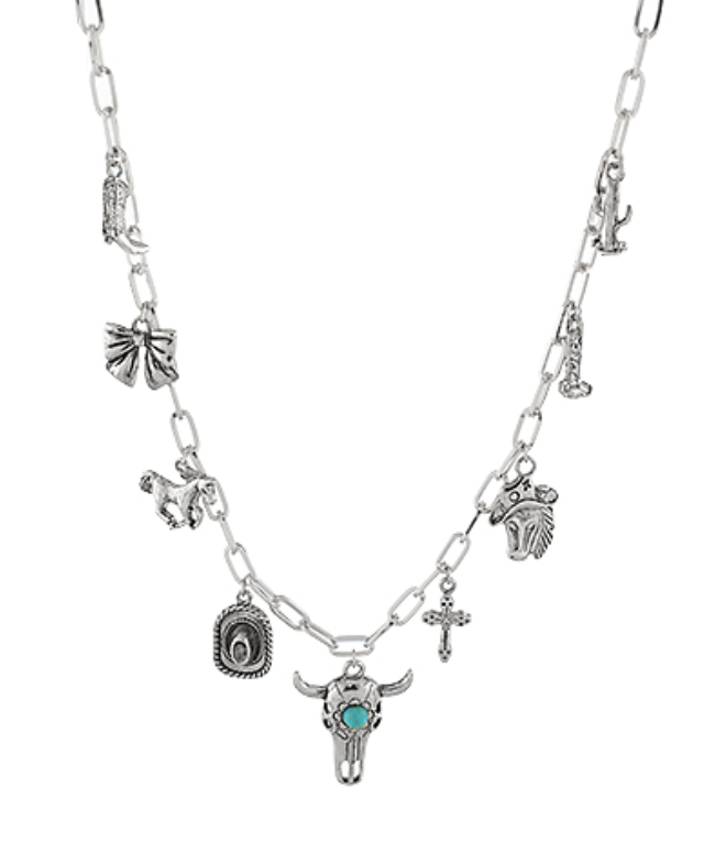 A silver-toned chunky link chain necklace adorned with an assortment of Western and Southwestern-inspired charms, including a cowboy boot, horseshoe, longhorn skull with a turquoise center, cowboy hat, horse, and various other unique silver-toned accents like a small cross and arrow.