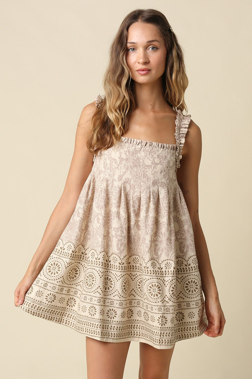 A breezy printed babydoll mini dress featuring a vintage-inspired print, ruffled shoulder straps, and a relaxed linen-blend silhouette made for effortless warm-weather style.
