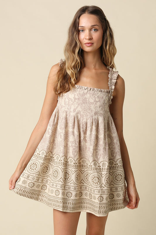 A breezy printed babydoll mini dress featuring a vintage-inspired print, ruffled shoulder straps, and a relaxed linen-blend silhouette made for effortless warm-weather style.
