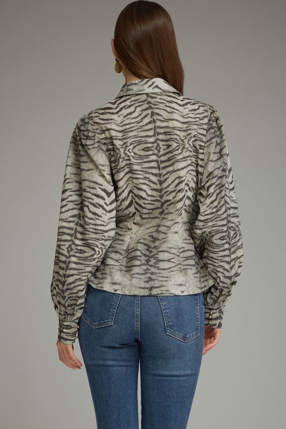 Make a bold style statement with this animal print crossover top featuring voluminous puff sleeves, a flattering buckle waist, and a feminine V-neckline.

