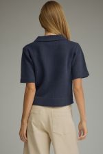 A lightweight argyle knit sweater featuring a classic collar, button-front closure, and ribbed trim for polished everyday layering.
