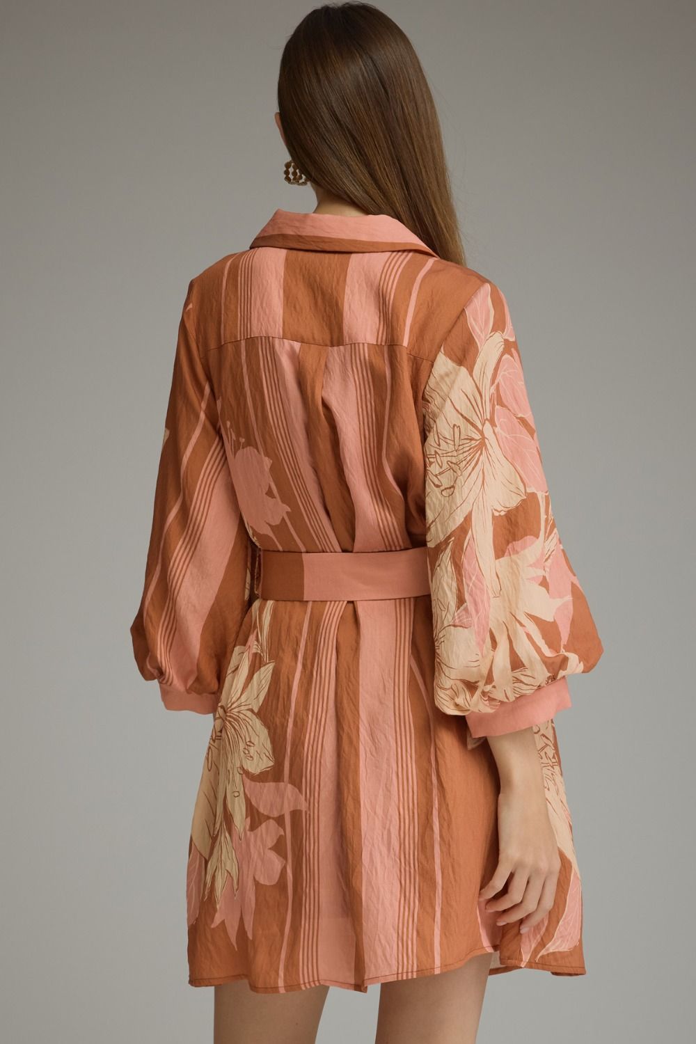 A feminine printed mini dress featuring dramatic balloon sleeves, a classic shirt collar, button-front closure, and a flattering self-tie waist.