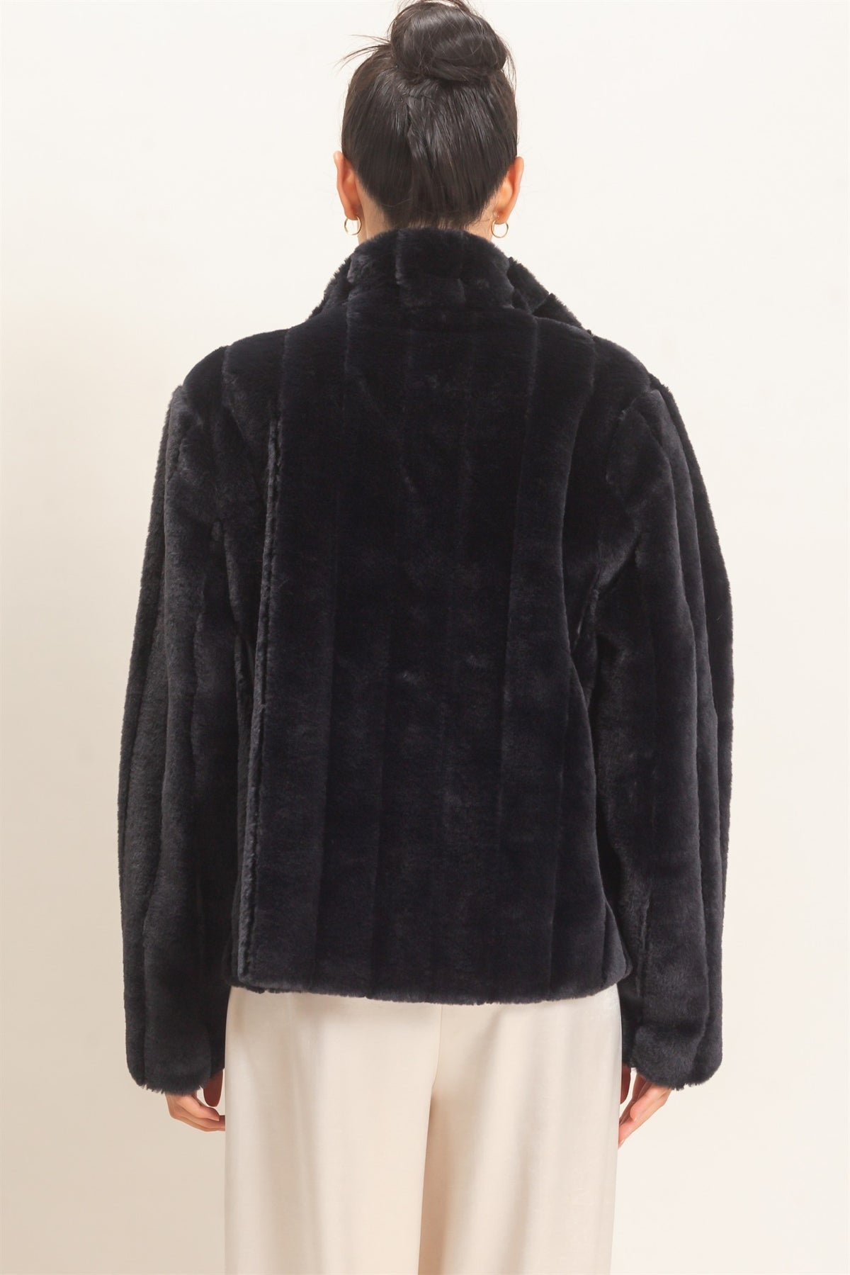 A luxurious faux fur jacket featuring a clean silhouette, cozy warmth, functional pockets, and an easy hook-and-eye front closure.

