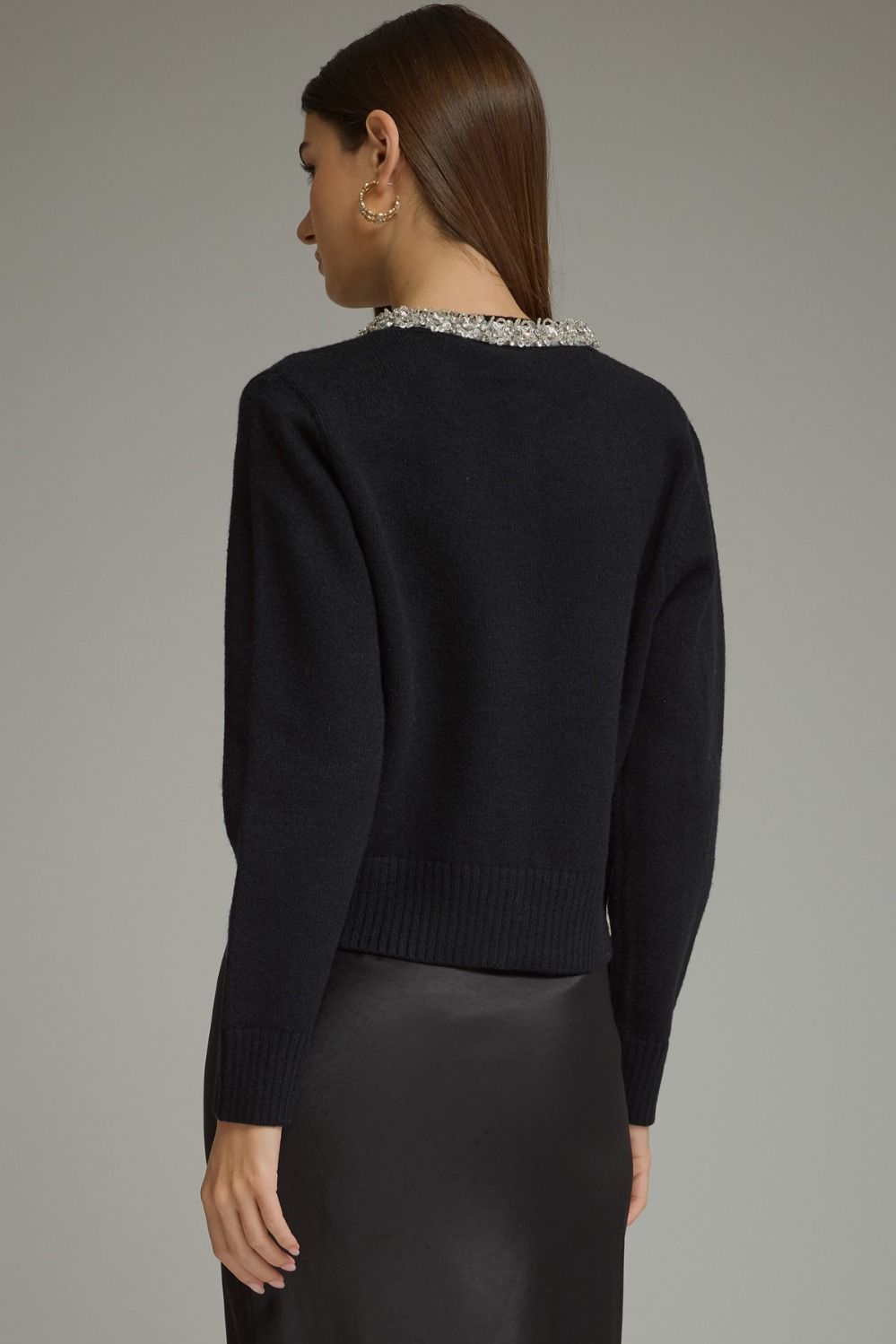 A polished knit cardigan featuring elegant rhinestone and pearl trim, pearl buttons, and classic ribbed details for a sophisticated feminine finish.