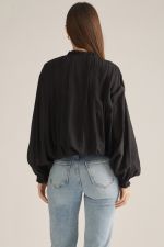 A romantic long-sleeve blouse featuring a ruffled high neckline, delicate front ruffle trim, and elegant button details for a timeless feminine look.

