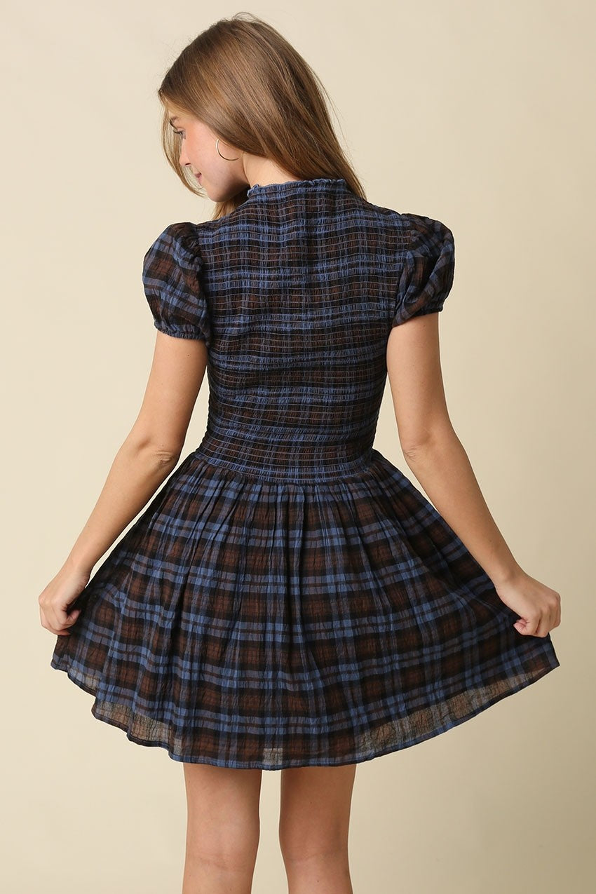 A timeless plaid mini dress featuring a flattering smocked bodice, feminine cap sleeves, and a softly gathered fit-and-flare skirt in breathable cotton.