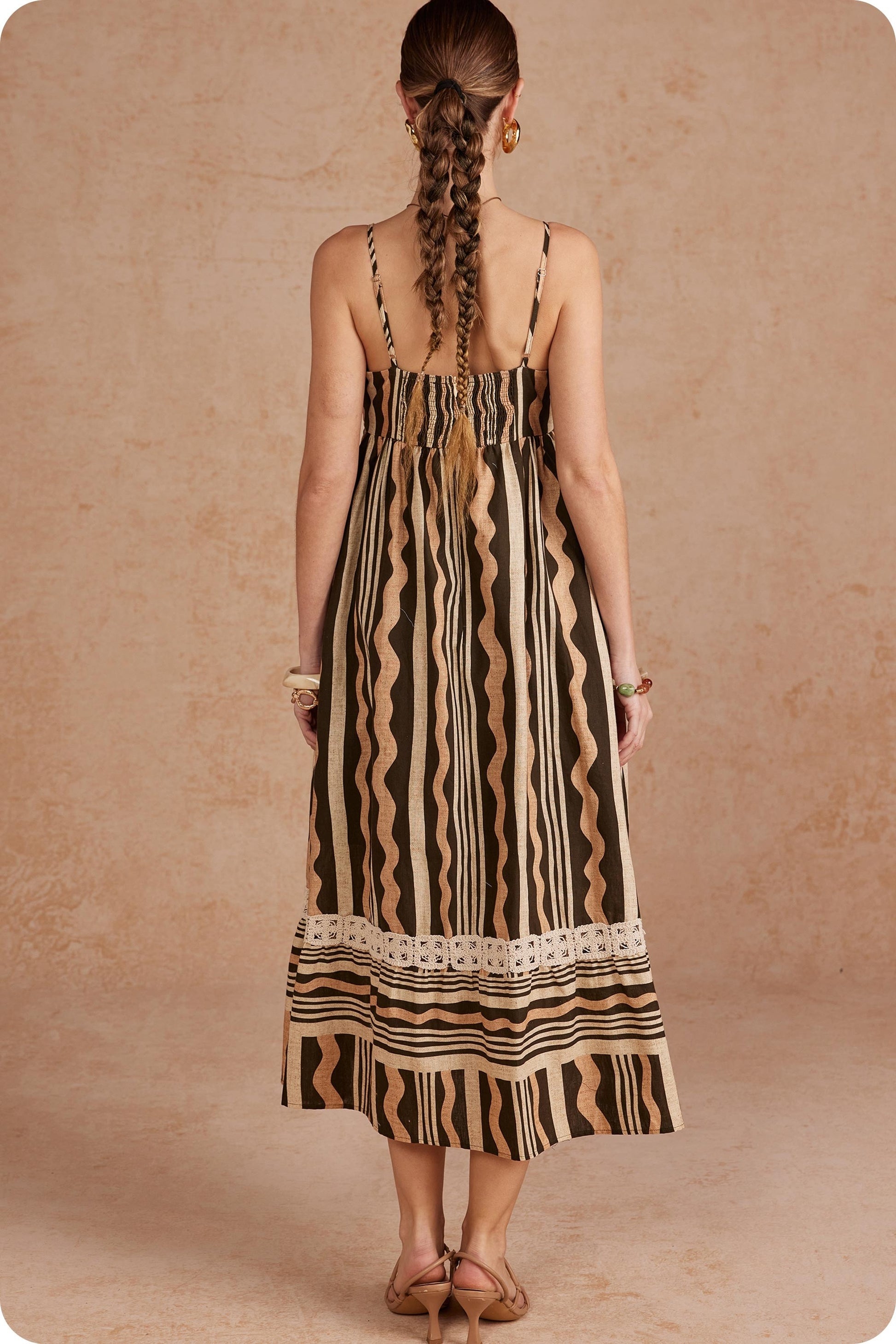 Effortlessly elegant and perfect for sunny days, this printed linen midi dress features delicate braided details and spaghetti straps for a timeless, feminine look.

