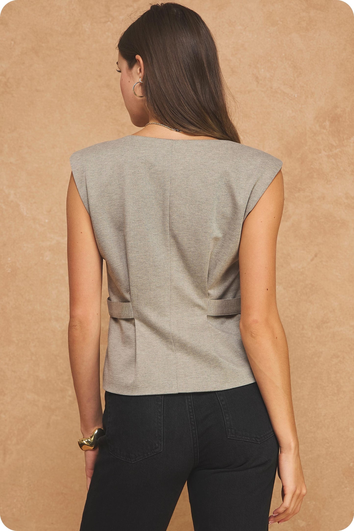 A polished tailored vest top featuring a structured V-neckline, metallic button detailing, and a flattering silhouette for effortless elevated style.