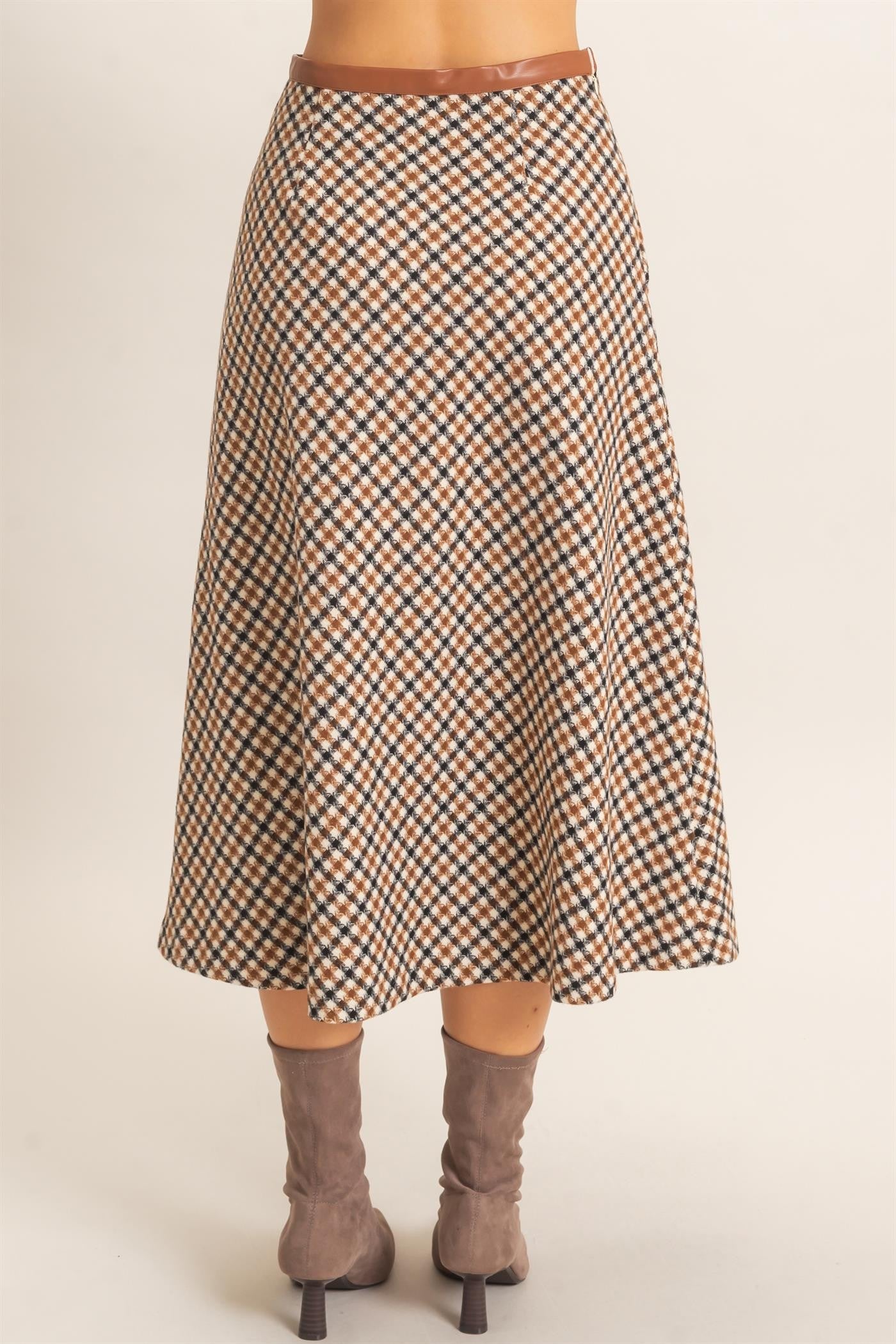 A sophisticated checkered A-line midi skirt featuring a sleek faux leather waistband and flattering flare for effortlessly polished style.
