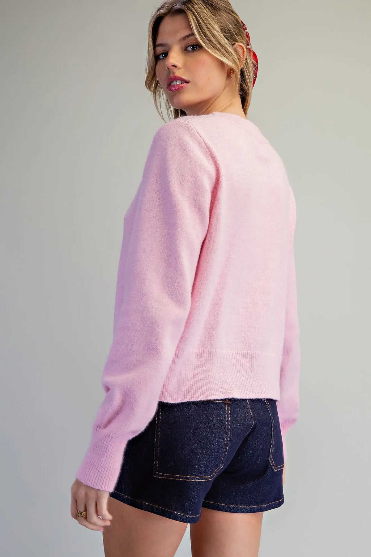 A cozy festive knit sweater featuring candy cane heart motifs, a classic crew neckline, and wide ribbed trims for a charming holiday look.