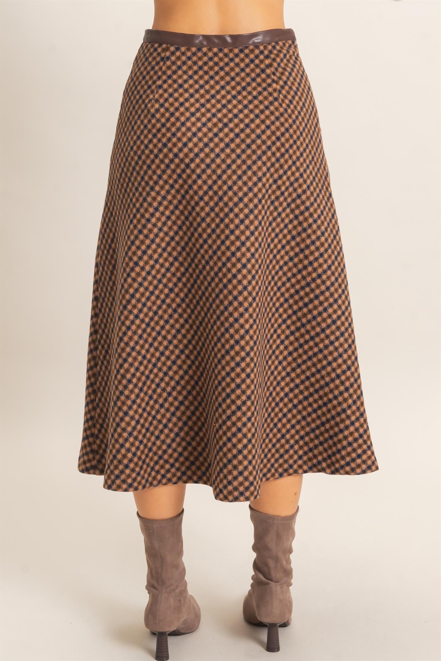 A sophisticated checkered A-line midi skirt featuring a sleek faux leather waistband and flattering flare for effortlessly polished style.
