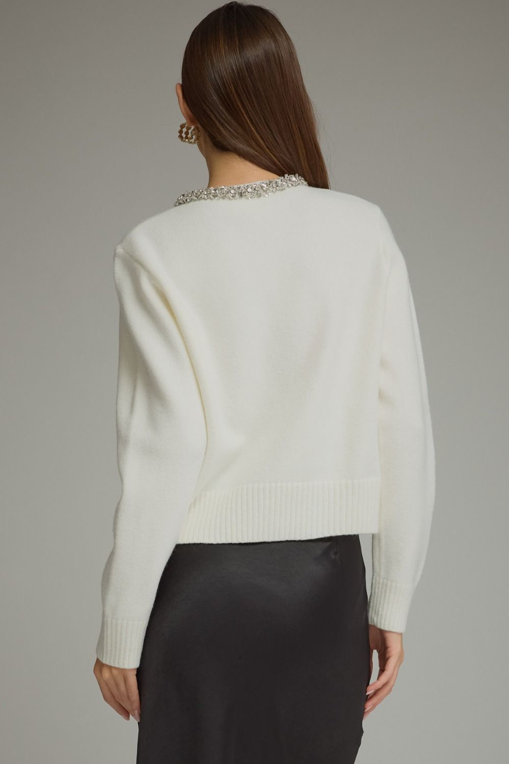 A polished knit cardigan featuring elegant rhinestone and pearl trim, pearl buttons, and classic ribbed details for a sophisticated feminine finish.