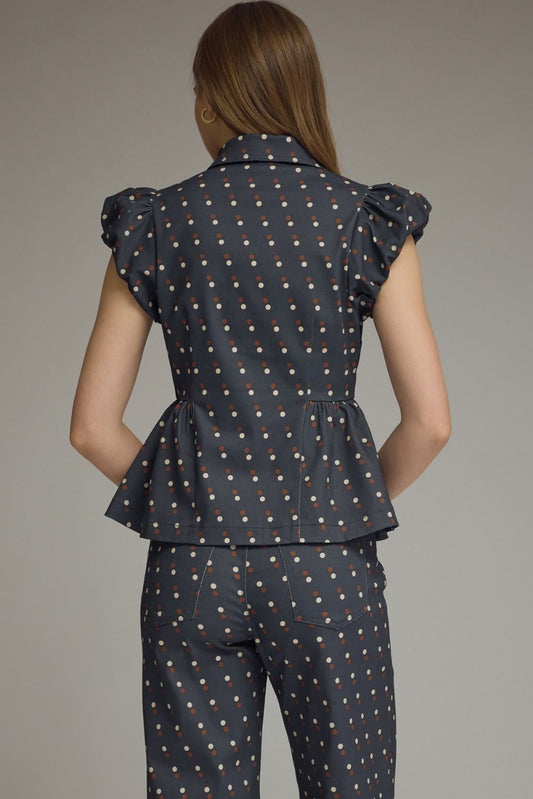 A playful polka dot denim top featuring cap sleeves, a collared neckline, and a flattering peplum hem for effortlessly feminine style.