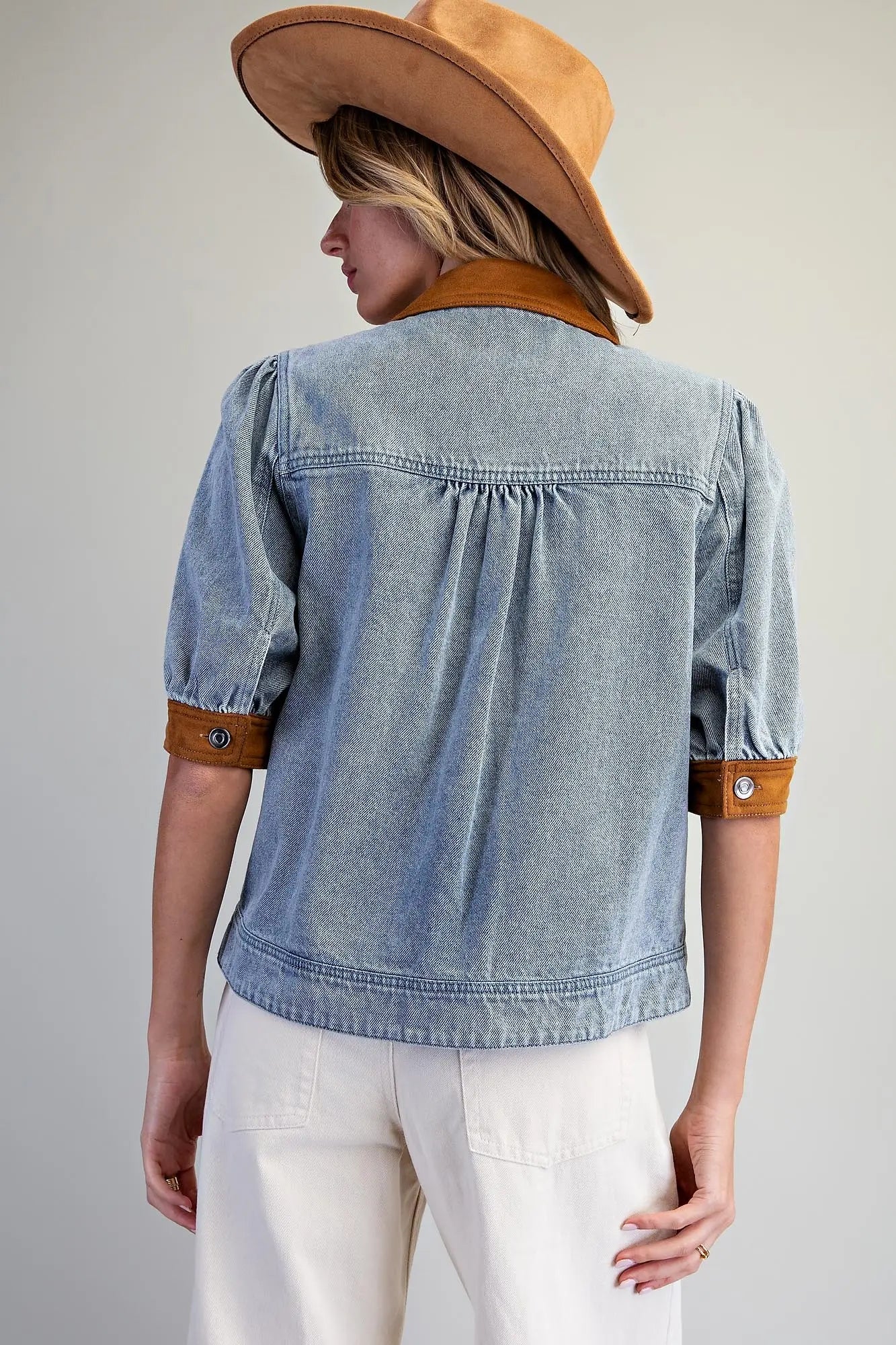 A fashion-forward mineral washed denim jacket accented with camel contrast trim, puff sleeves, and classic metal buttons for an elevated everyday layer.
