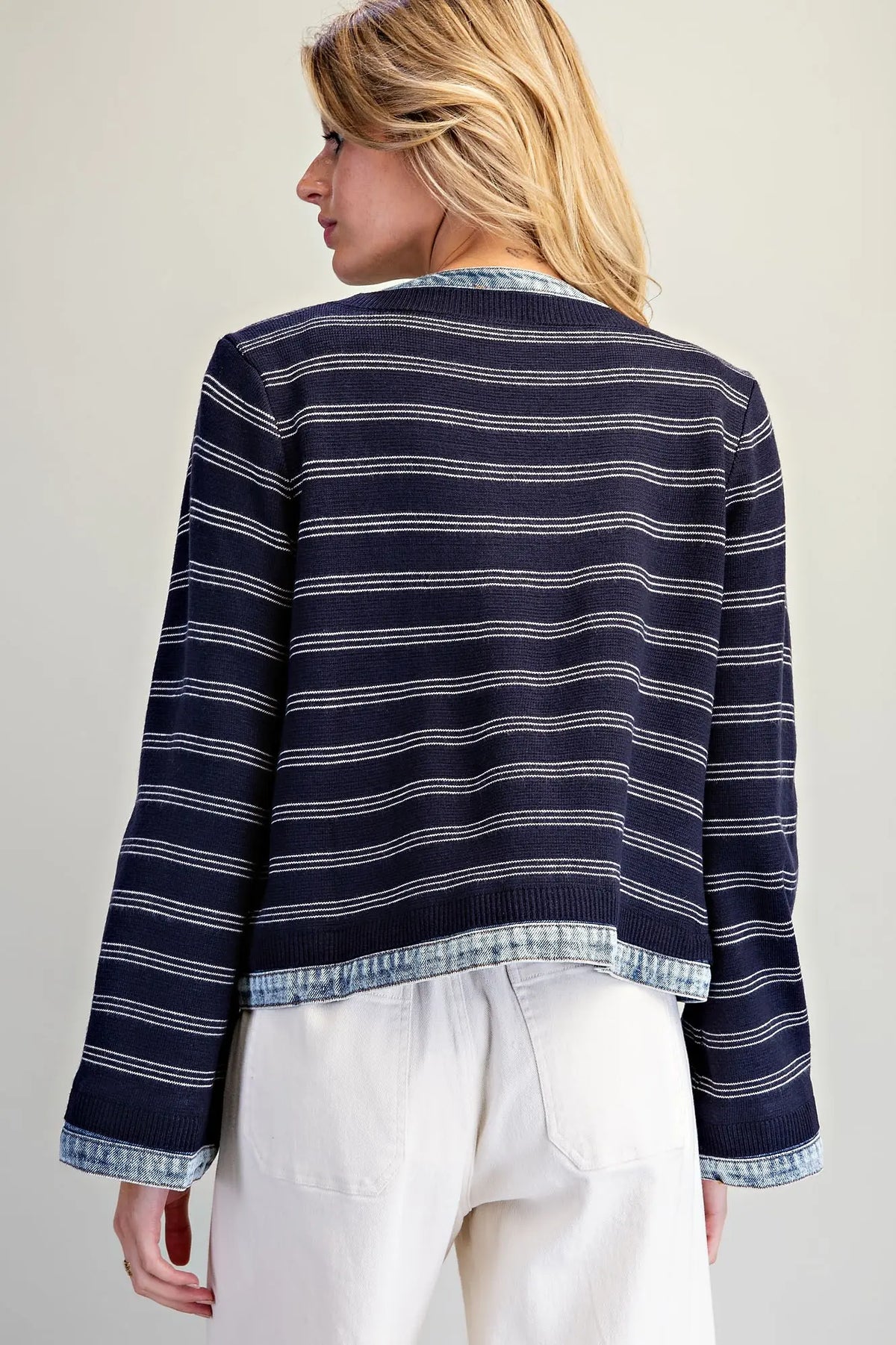 A casually chic striped knit jacket featuring contrasting washed denim trim, a zip-front closure, and a slightly cropped silhouette.
