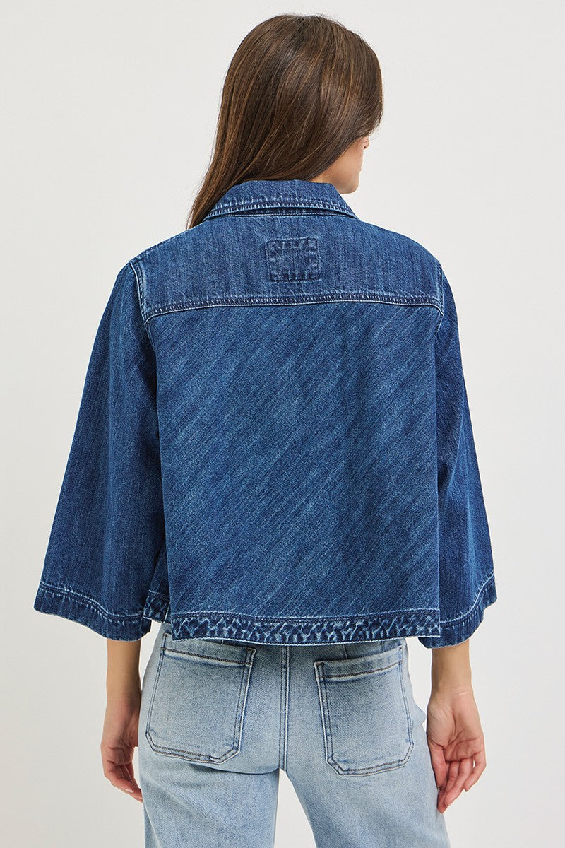 The Bernadette Flowy Cropped Denim Jacket gives classic denim a fresh feminine update with a wide, relaxed silhouette, button front, and voluminous sleeves.