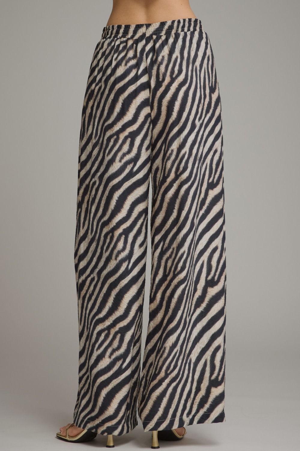 Make a bold statement in these lightweight zebra print wide leg pants featuring a comfortable elastic waistband and adjustable drawstring detail.