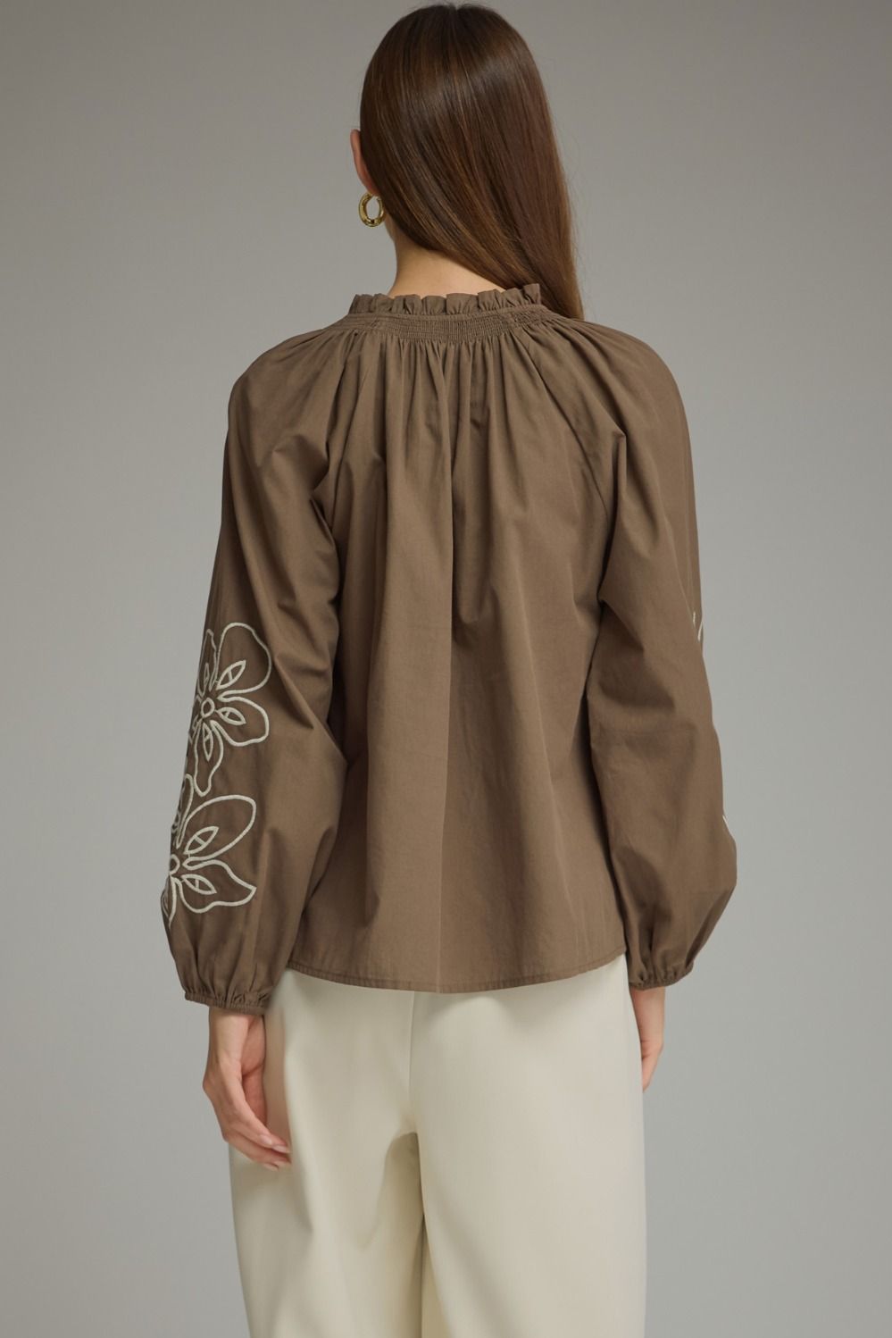 A charming lightweight woven top featuring a romantic ruffle neckline, self-tie front, and delicate embroidery for effortlessly feminine style.

