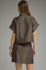 A polished two-piece set featuring a chic cropped top with wide cuffed sleeves paired with a sleek mini skirt for an effortlessly coordinated look.