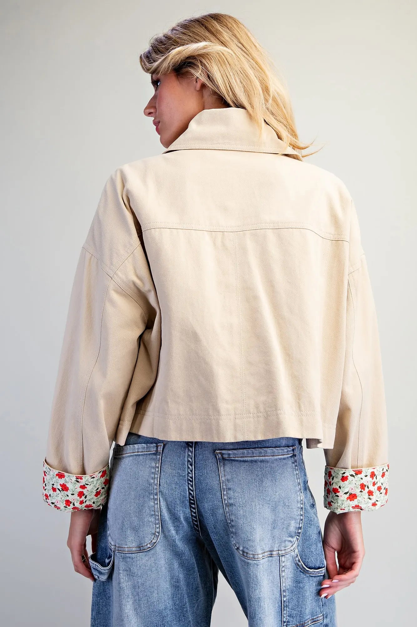 The Marjorie Floral Lined Cropped Jacket pairs a relaxed beige silhouette with a vibrant floral lining for a sophisticated statement layer with a playful twist.
