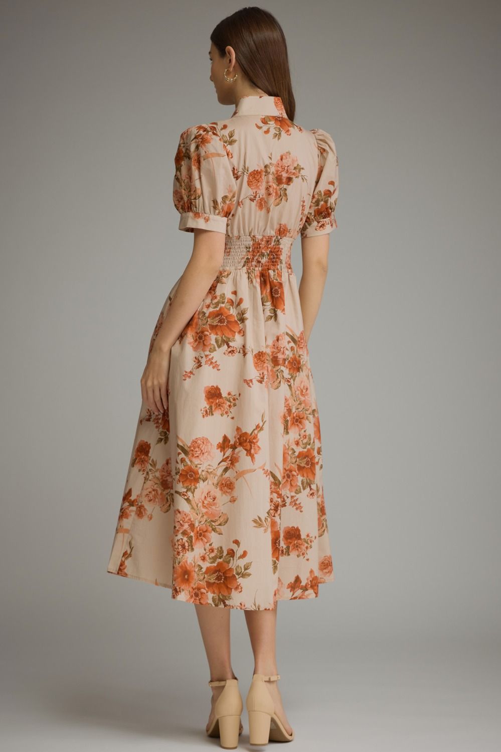 A feminine floral midi dress featuring short puff sleeves, a chic stand collar, a front zipper, and a flattering smocked waist.
